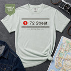 Light blue t-shirt with '72 Street' design on a dark surface with a map and denim jacket.