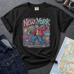 Black Comfort Colors t-shirt featuring a colorful NYC graffiti-style New York graphic with a young street artist holding a spray paint can