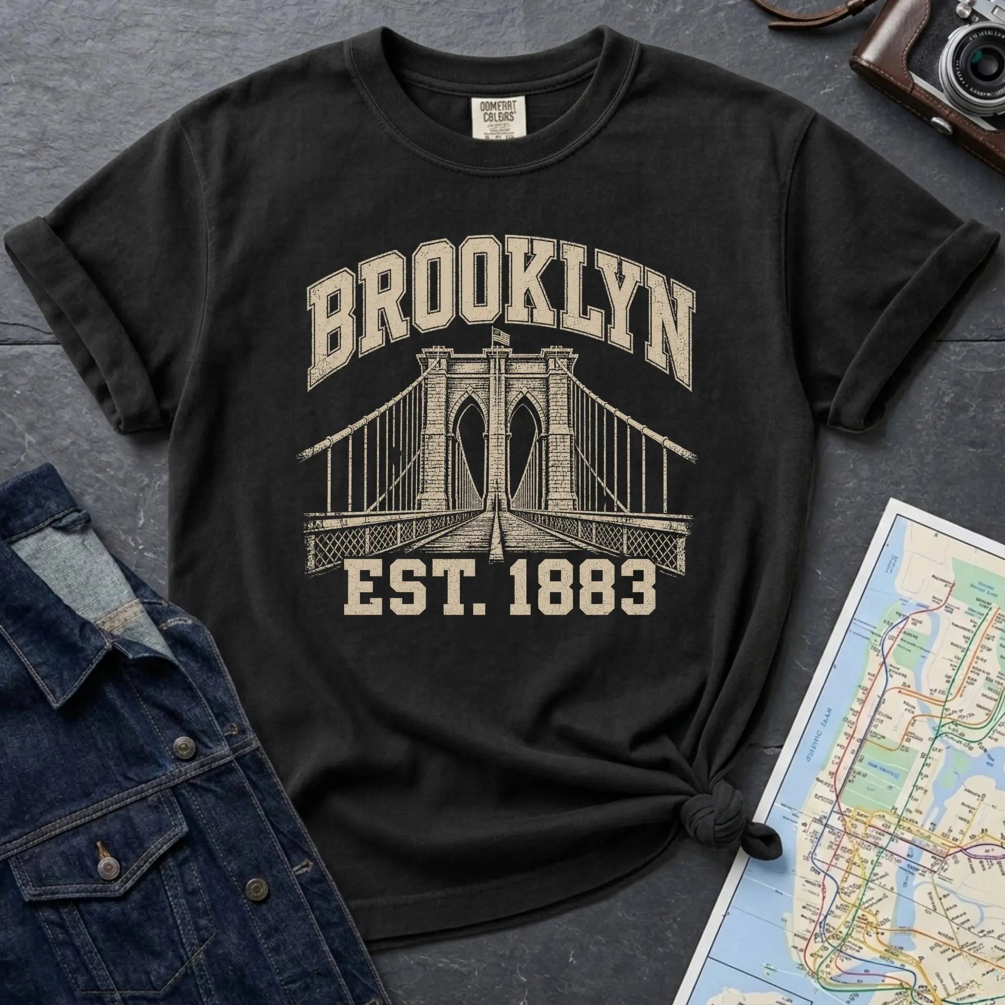 Black Comfort Colors t-shirt featuring a vintage Brooklyn Bridge graphic with bold Brooklyn text and “Est. 1883” lettering.