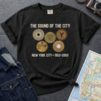 Black Comfort Colors t-shirt featuring vintage New York City subway tokens with “The Sound of the City” and “New York City • 1953–2003” text.