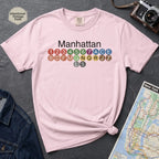 Pink Comfort Colors t-shirt featuring a minimalist Manhattan subway line graphic with colorful NYC train icons.