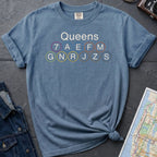Blue Comfort Colors t-shirt featuring a minimalist Queens subway line graphic with Queens text and classic NYC train icons.