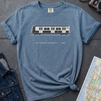 Blue Comfort Colors t-shirt featuring a minimalist New York City subway car graphic with “NYC Transit Authority • 1987” text.