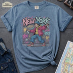 Blue Comfort Colors t-shirt featuring a colorful NYC graffiti-style New York graphic with a young street artist holding a spray paint can