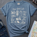 Blue Comfort Colors t-shirt featuring a New York Life Was the Best Life graphic with hand-drawn NYC nostalgia icons including a MetroCard, cassette tape, pay phone, coffee cup, newspaper, pizza slice, fire hydrant, Walkman, and bodega cat.