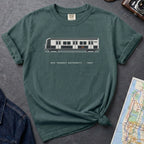 Blue Spruce Comfort Colors t-shirt featuring a minimalist New York City subway car graphic with “NYC Transit Authority • 1987” text.