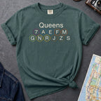 Blue Spruce Comfort Colors t-shirt featuring a minimalist Queens subway line graphic with Queens text and classic NYC train icons.