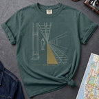 Blue Spruce Comfort Colors t-shirt featuring a minimalist NYC subway platform graphic with a lone figure, train tracks, and “Stand Clear” text.