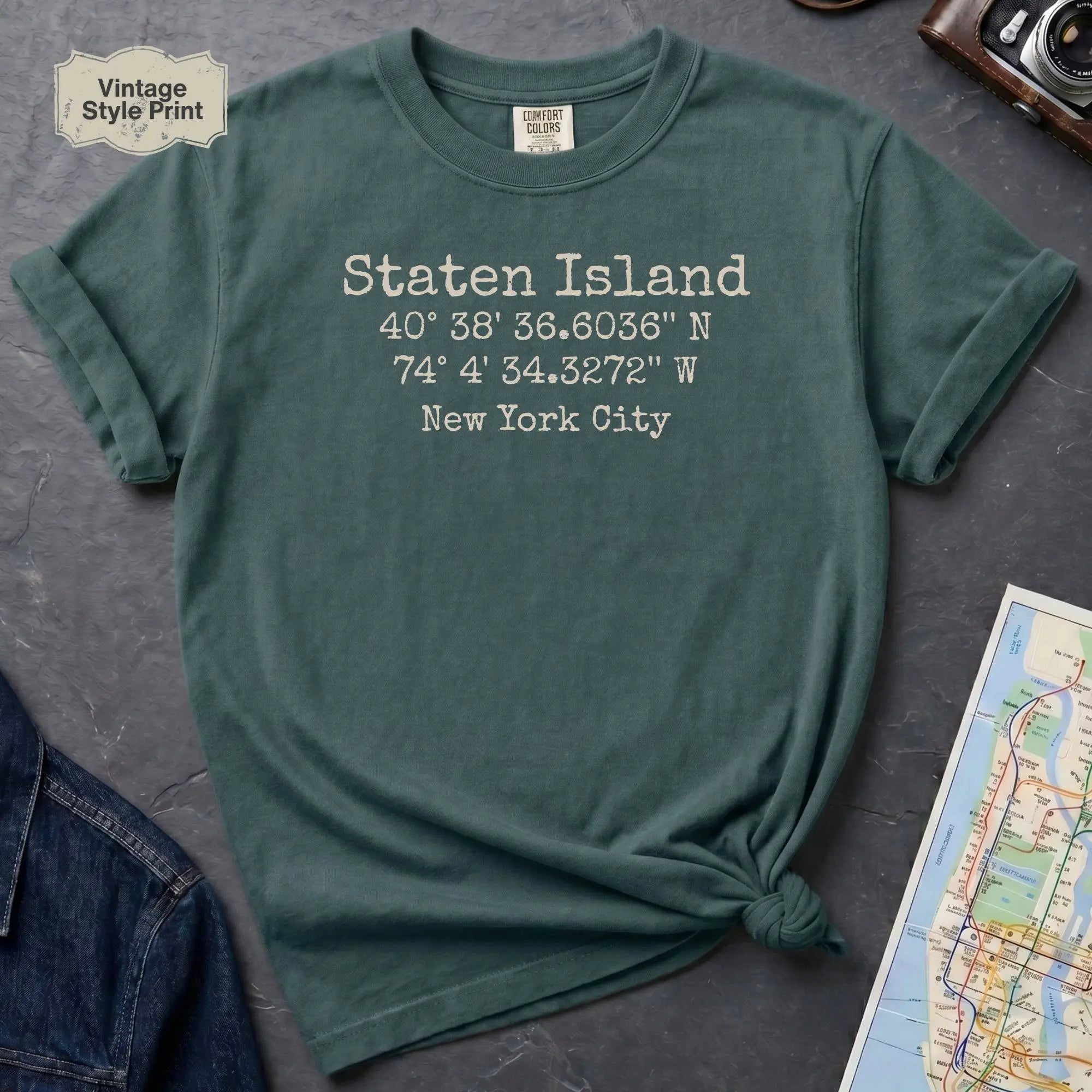 Blue Spruce Comfort Colors t-shirt featuring a minimalist Staten Island coordinates design with “Staten Island,” latitude and longitude, and “New York City” printed in a vintage-style font.