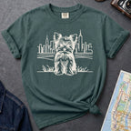 Blue spruce Comfort Colors t-shirt featuring a minimalist Yorkshire Terrier (Yorkie) illustration in front of the New York City skyline.