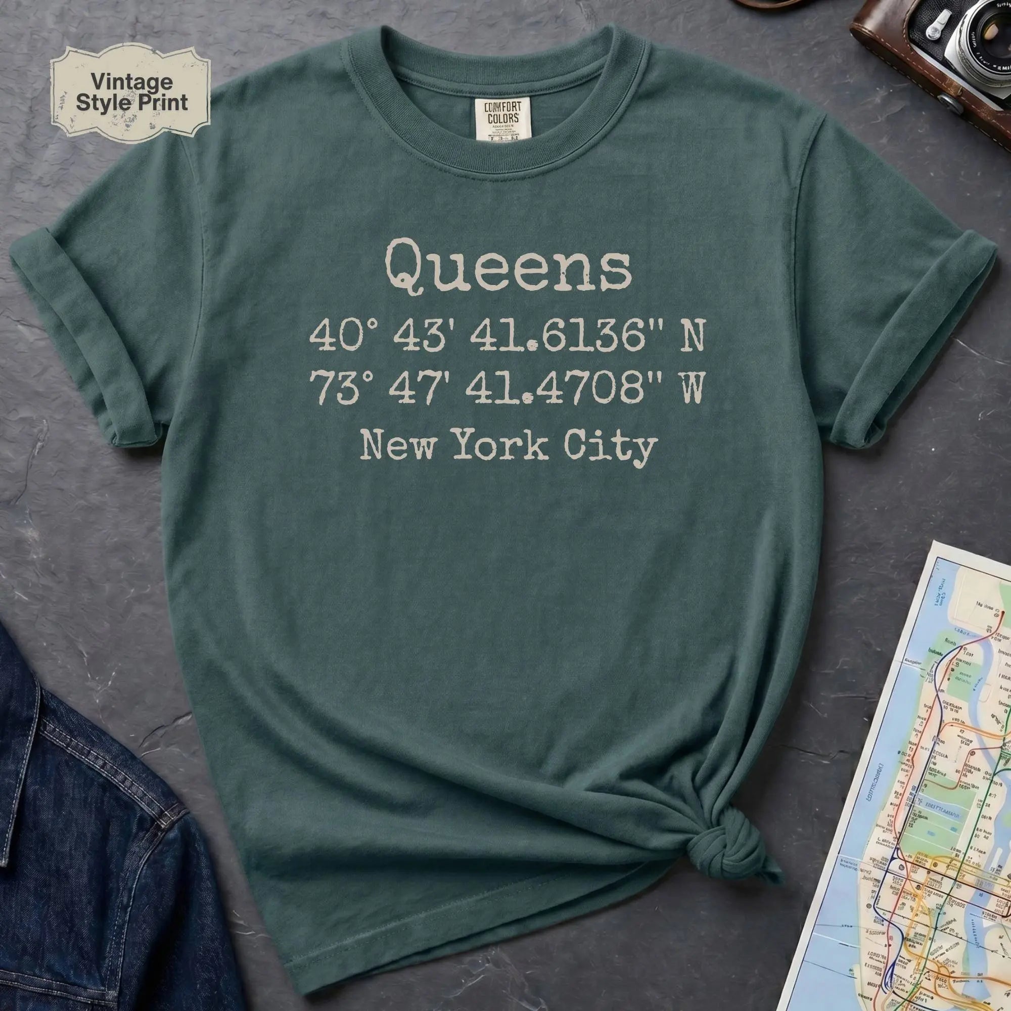 Blue spruce Comfort Colors t-shirt featuring Queens, NY coordinates and New York City text in a minimalist typewriter-style design.