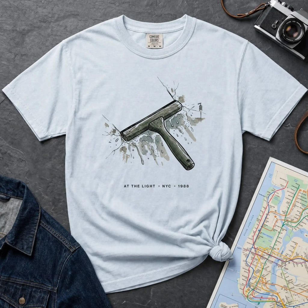 Light blue Comfort Colors t-shirt featuring a vintage windshield squeegee graphic with “At the Light • NYC • 1988” text.