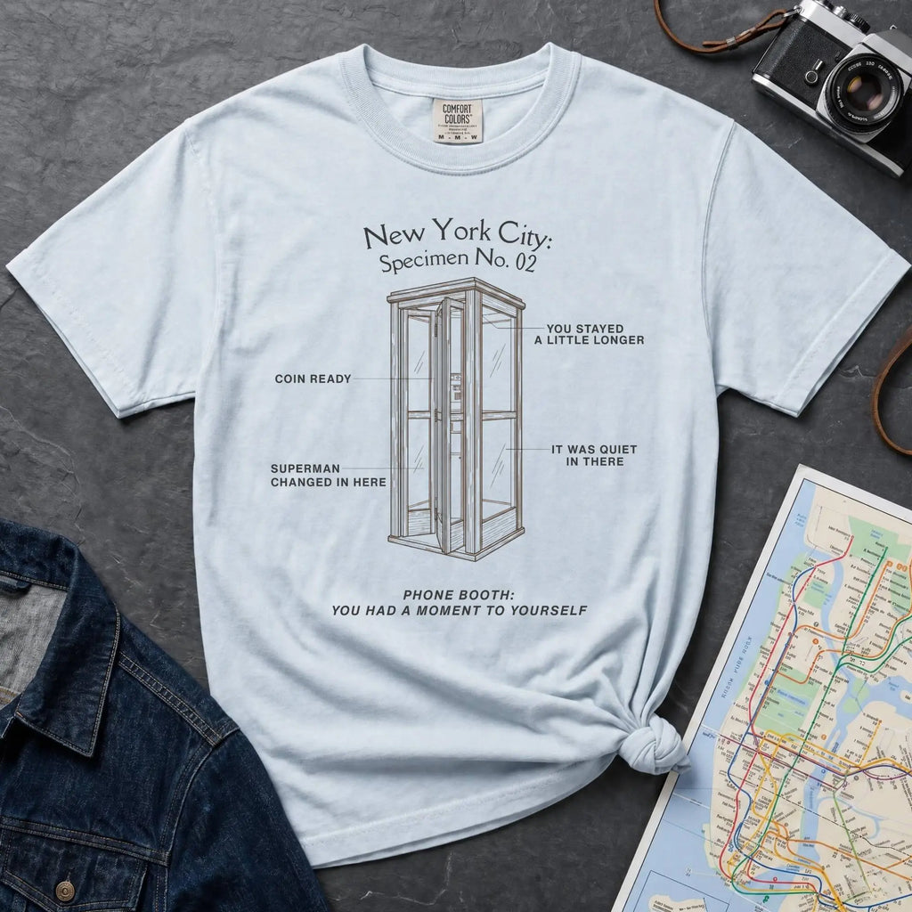 Light blue Comfort Colors t-shirt featuring a vintage New York City phone booth graphic with specimen-style callouts and “Phone Booth: You Had a Moment to Yourself” text.