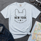 Light blue Comfort Colors t-shirt featuring a New York French Bulldog Club graphic with bold text, outlined French bulldog ears, stars, and a minimalist black design.