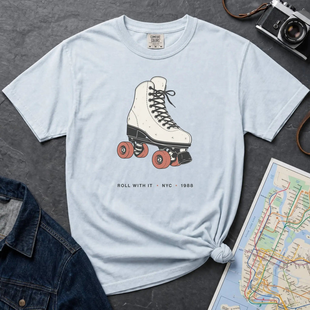 Light blue Comfort Colors t-shirt featuring a vintage roller skate graphic with “Roll With It • NYC • 1988” text.