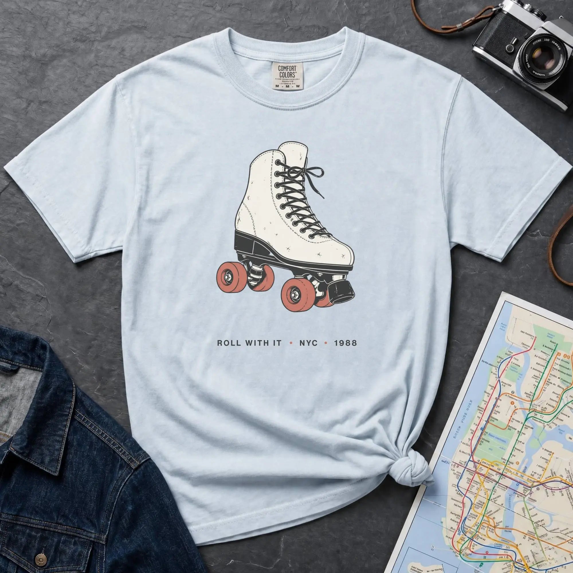 Light blue Comfort Colors t-shirt featuring a vintage roller skate graphic with “Roll With It • NYC • 1988” text.
