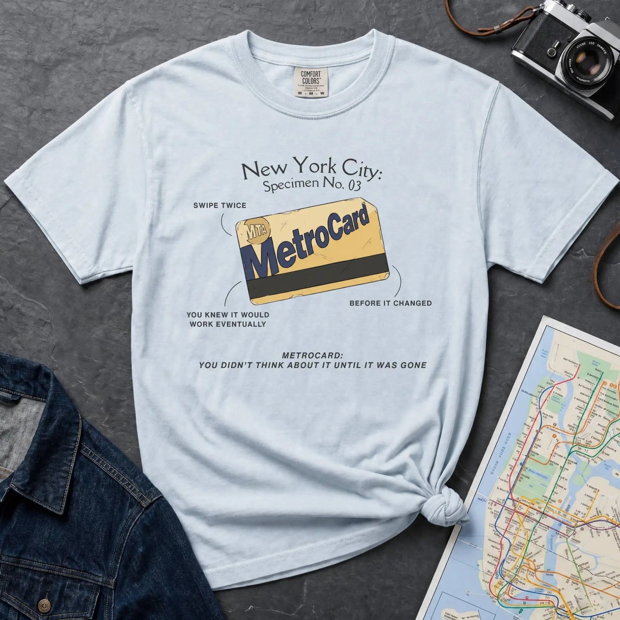 Light blue Comfort Colors t-shirt featuring a vintage New York City MetroCard graphic with specimen-style callouts and “You didn’t think about it until it was gone” text.