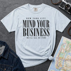 Light blue Comfort Colors t-shirt featuring bold New York City “Mind Your Business, We’ll All Be Fine” text in a vintage black typography design.