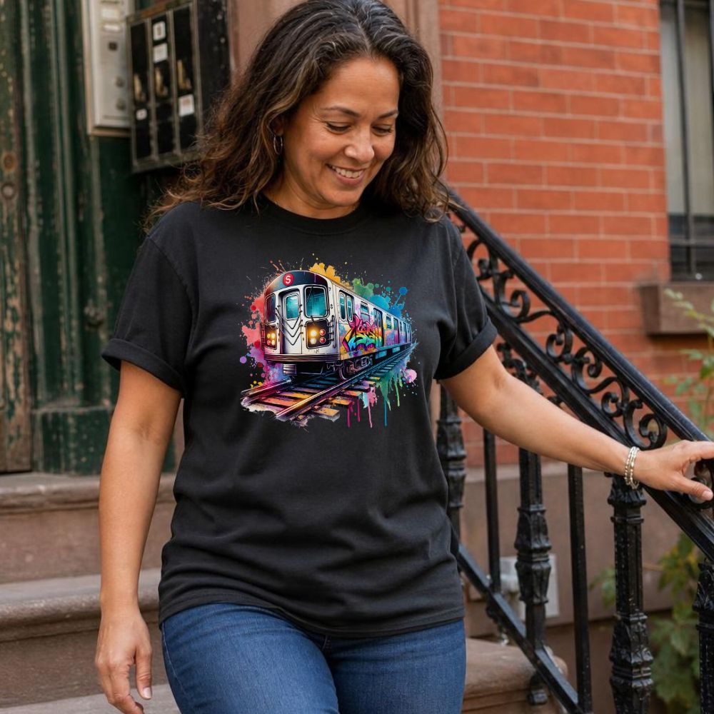 Woman wearing a black Comfort Colors t-shirt with a colorful graffiti NYC subway train graphic, standing on a street.