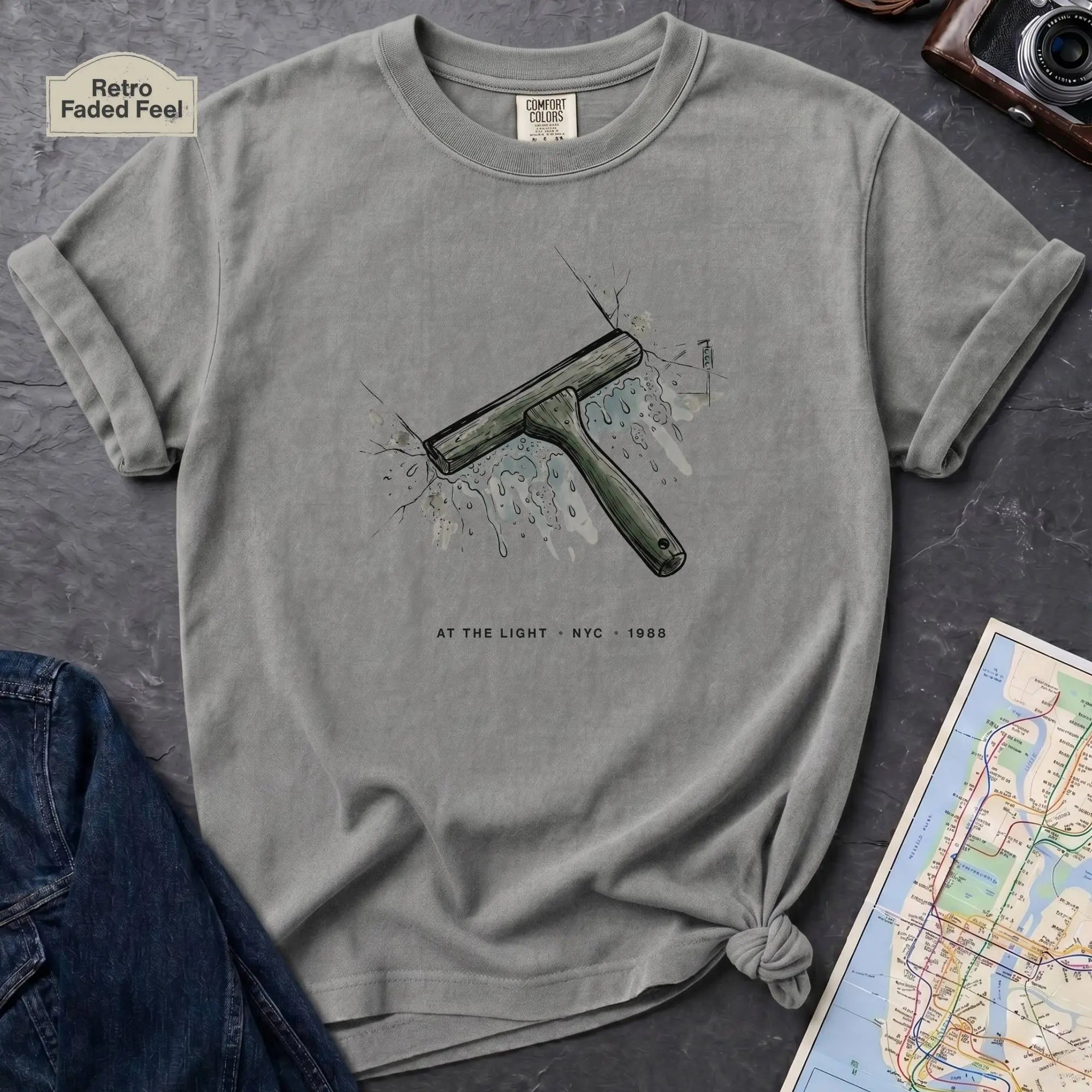 Granite colored Comfort Colors t-shirt featuring a vintage windshield squeegee graphic with “At the Light • NYC • 1988” text.