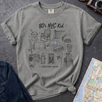 Granite colored Comfort Colors t-shirt featuring an 80’s NYC Kid Starter Pack graphic with hand-drawn New York City icons including Italian ice, a radio, stoop steps, stickball, a fire hydrant, and a pigeon.