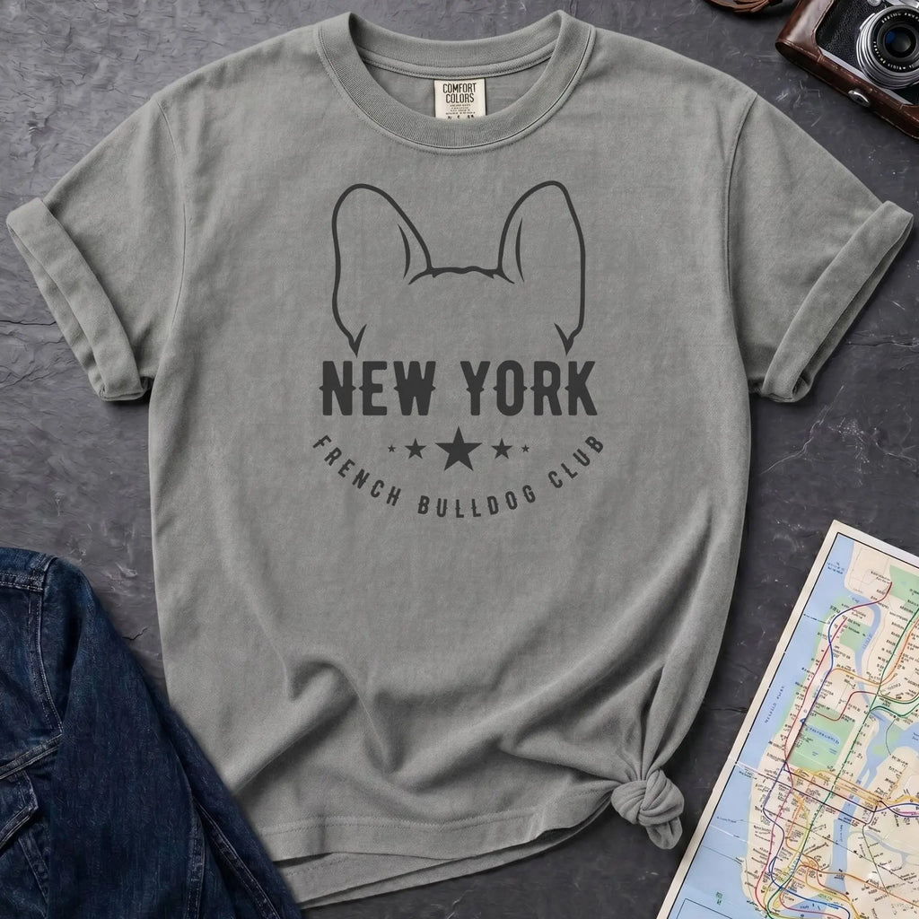 Granite colored Comfort Colors t-shirt featuring a New York French Bulldog Club graphic with bold text, outlined French bulldog ears, stars, and a minimalist black design.