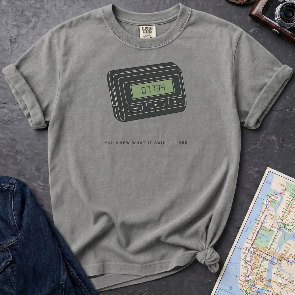 Granite colored Comfort Colors t-shirt featuring a retro pager graphic with “07734” on the screen and “You knew what it said • 1989” text.
