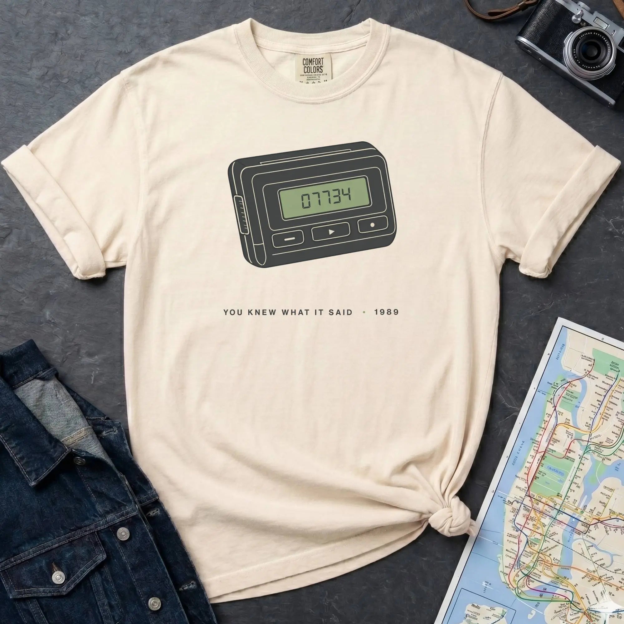 Ivory Comfort Colors t-shirt featuring a retro pager graphic with “07734” on the screen and “You knew what it said • 1989” text.