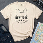Ivory Comfort Colors t-shirt featuring a New York French Bulldog Club graphic with bold text, outlined French bulldog ears, stars, and a minimalist black design.