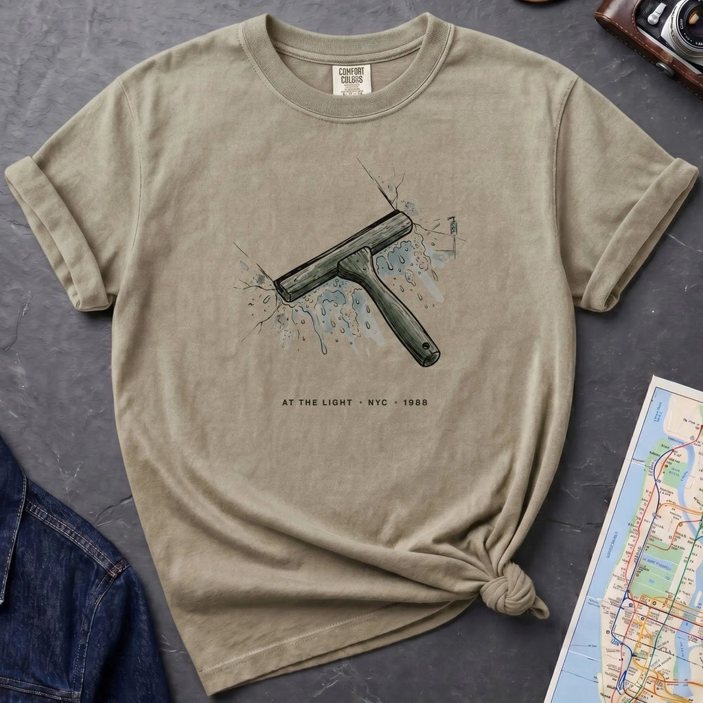 Khaki colored Comfort Colors t-shirt featuring a vintage windshield squeegee graphic with “At the Light • NYC • 1988” text.