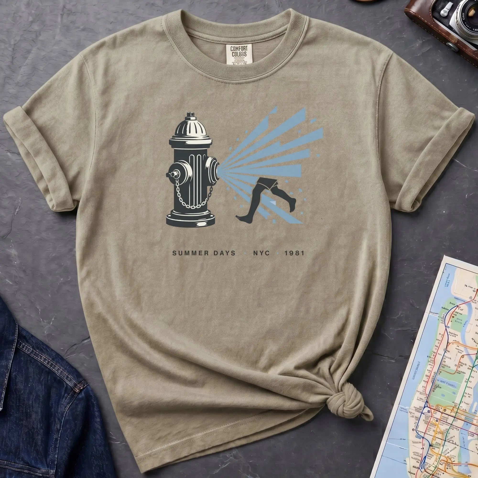 Khaki colored Comfort Colors t-shirt featuring a vintage NYC fire hydrant spraying water with “Summer Days • NYC • 1981” text.