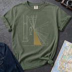 Moss green Comfort Colors t-shirt featuring a minimalist NYC subway platform graphic with a lone figure, train tracks, and “Stand Clear” text.