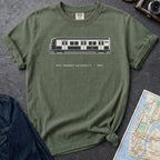 Moss green Comfort Colors t-shirt featuring a minimalist New York City subway car graphic with “NYC Transit Authority • 1987” text.