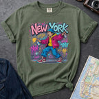 Moss green Comfort Colors t-shirt featuring a colorful NYC graffiti-style New York graphic with a young street artist holding a spray paint can