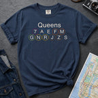 Navy Comfort Colors t-shirt featuring a minimalist Queens subway line graphic with Queens text and classic NYC train icons.