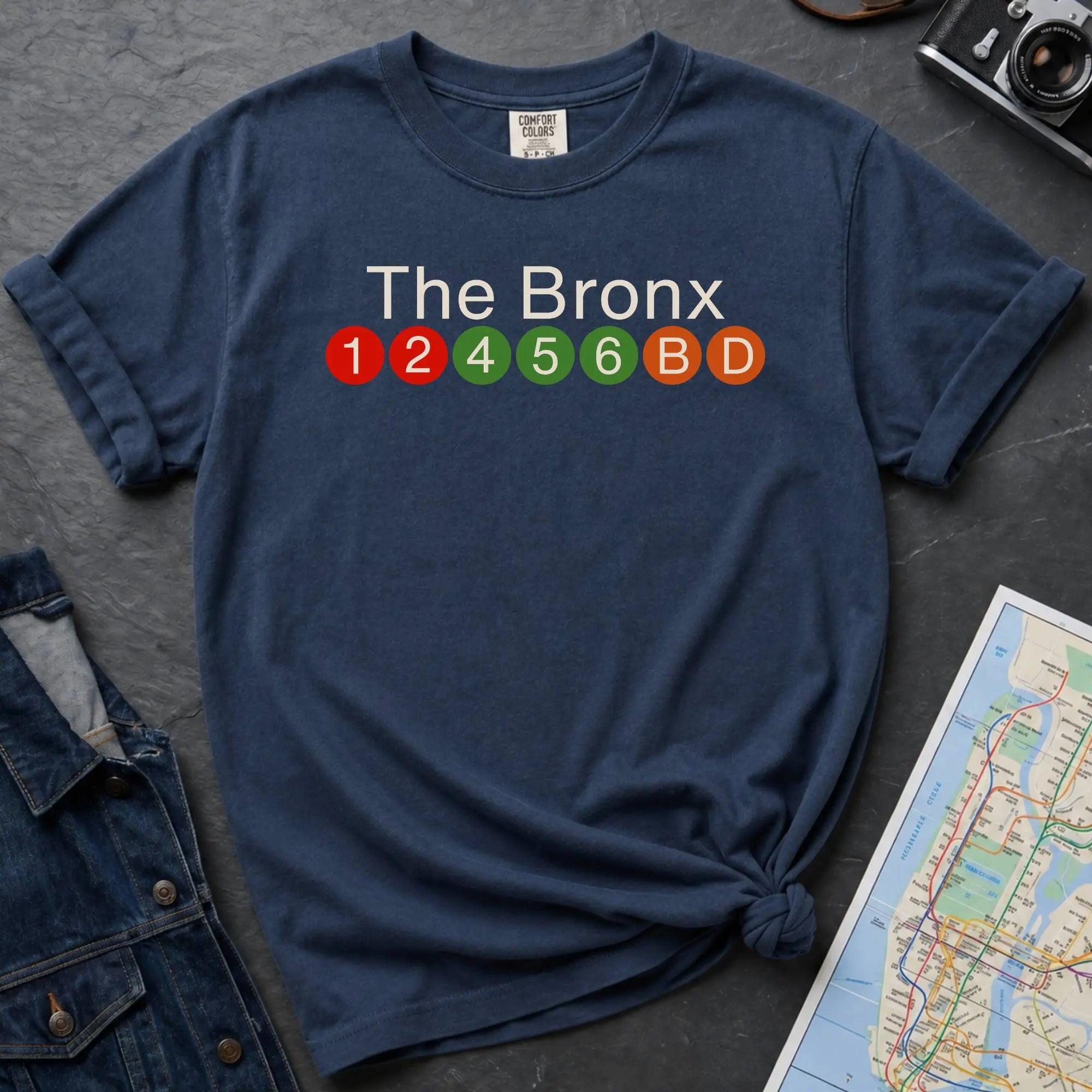 NavyComfort Colors t-shirt featuring a minimalist Bronx subway line graphic with The Bronx text and colorful NYC train icons.