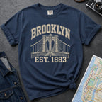 Navy Comfort Colors t-shirt featuring a vintage Brooklyn Bridge graphic with bold Brooklyn text and “Est. 1883” lettering.