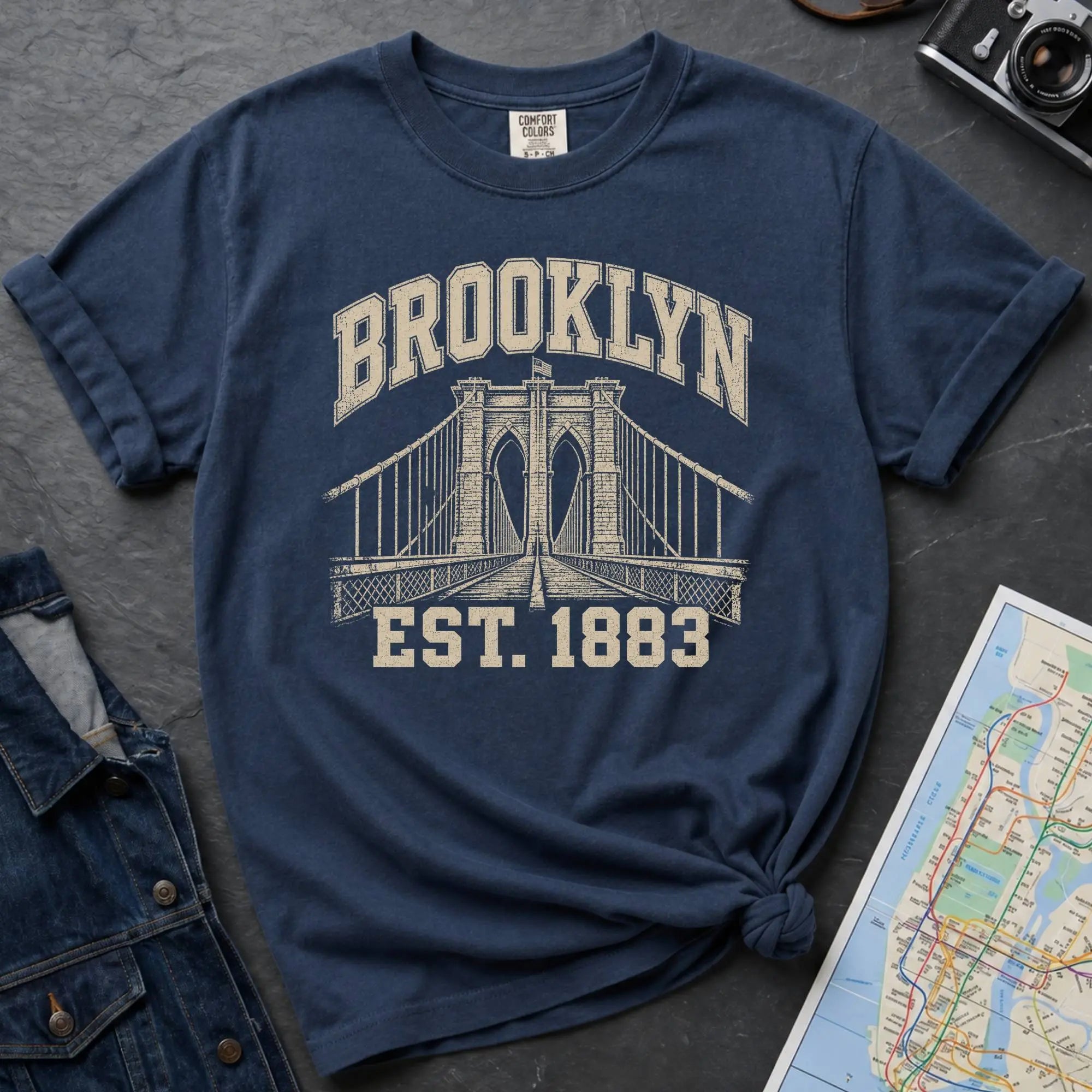 Navy Comfort Colors t-shirt featuring a vintage Brooklyn Bridge graphic with bold Brooklyn text and “Est. 1883” lettering.