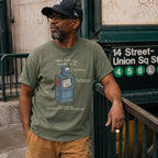 A man wearing a Moss green t-shirt with a newspaper box graphic and text