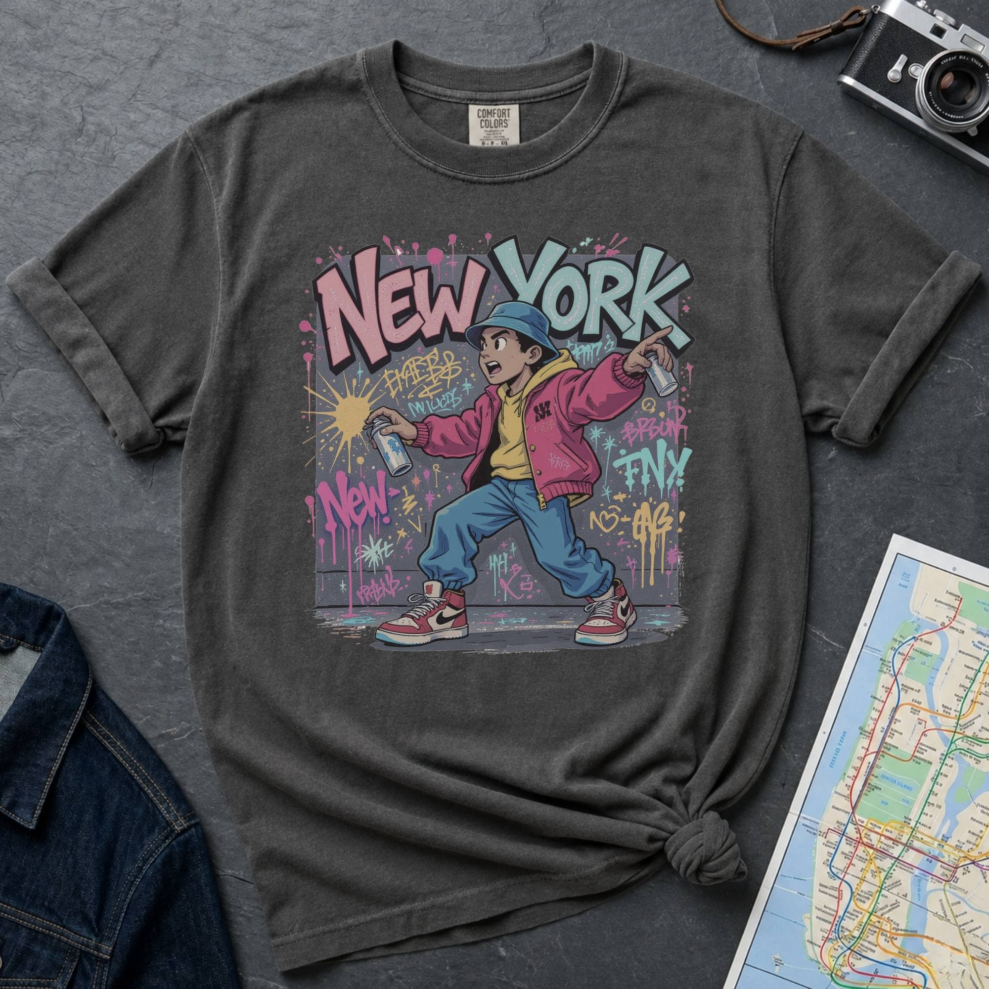 Pepper colored Comfort Colors t-shirt featuring a colorful NYC graffiti-style New York graphic with a young street artist holding a spray paint can