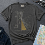 Pepper colored Comfort Colors t-shirt featuring a minimalist NYC subway platform graphic with a lone figure, train tracks, and “Stand Clear” text.