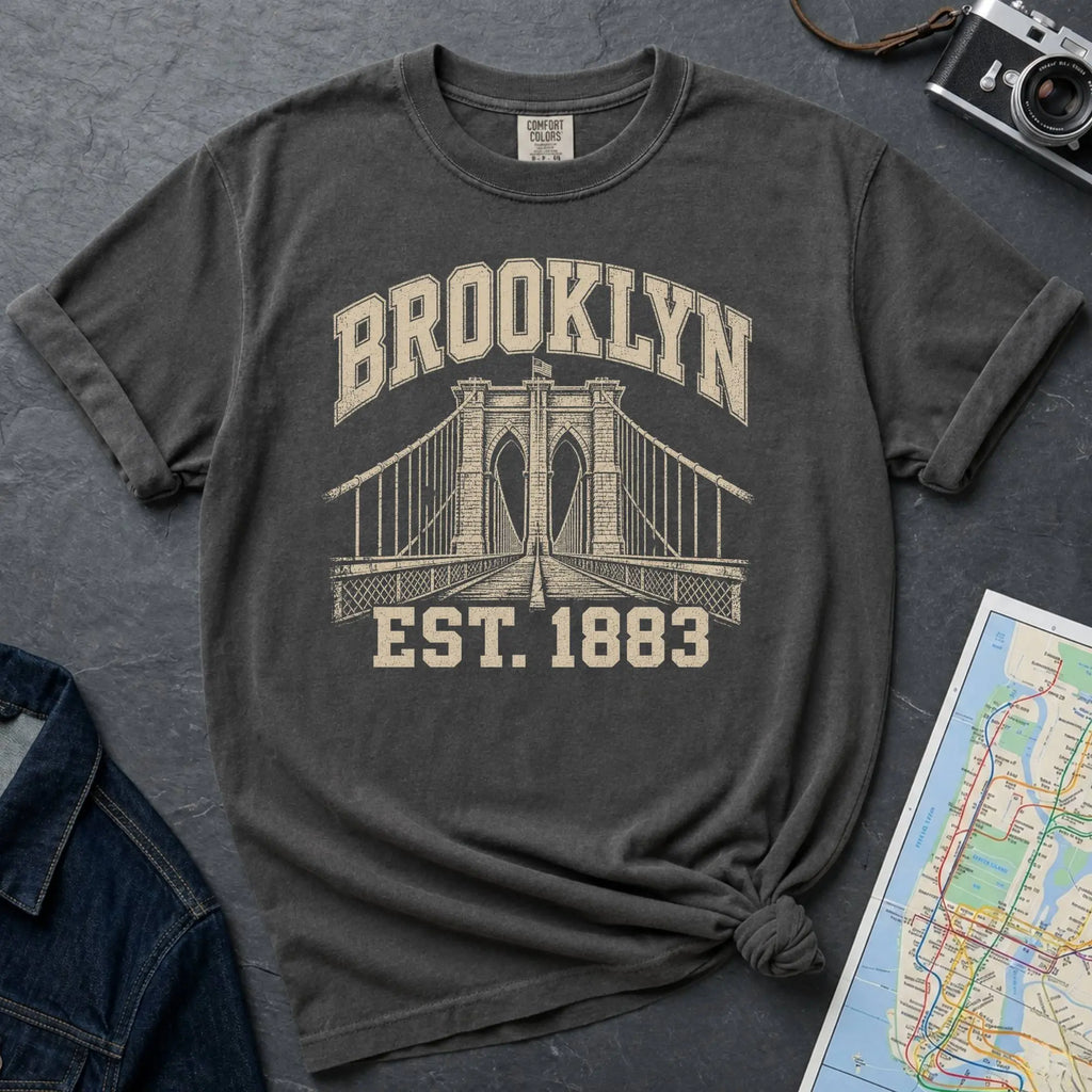 Pepper colored Comfort Colors t-shirt featuring a vintage Brooklyn Bridge graphic with bold Brooklyn text and “Est. 1883” lettering.