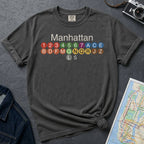 Pepper colored Comfort Colors t-shirt featuring a minimalist Manhattan subway line graphic with colorful NYC train icons.