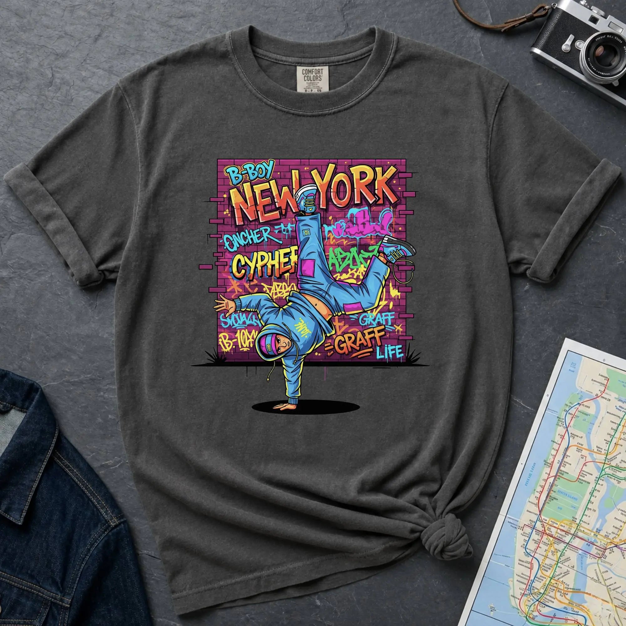 Pepper colored Comfort Colors t-shirt featuring a colorful B-Boy New York graphic with a breakdancer in front of a graffiti brick wall.