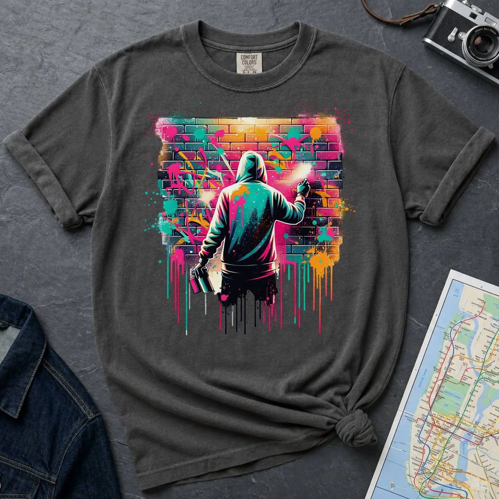 Pepper colored t-shirt with a graphic of a person spray painting a colorful mural on a brick wall.