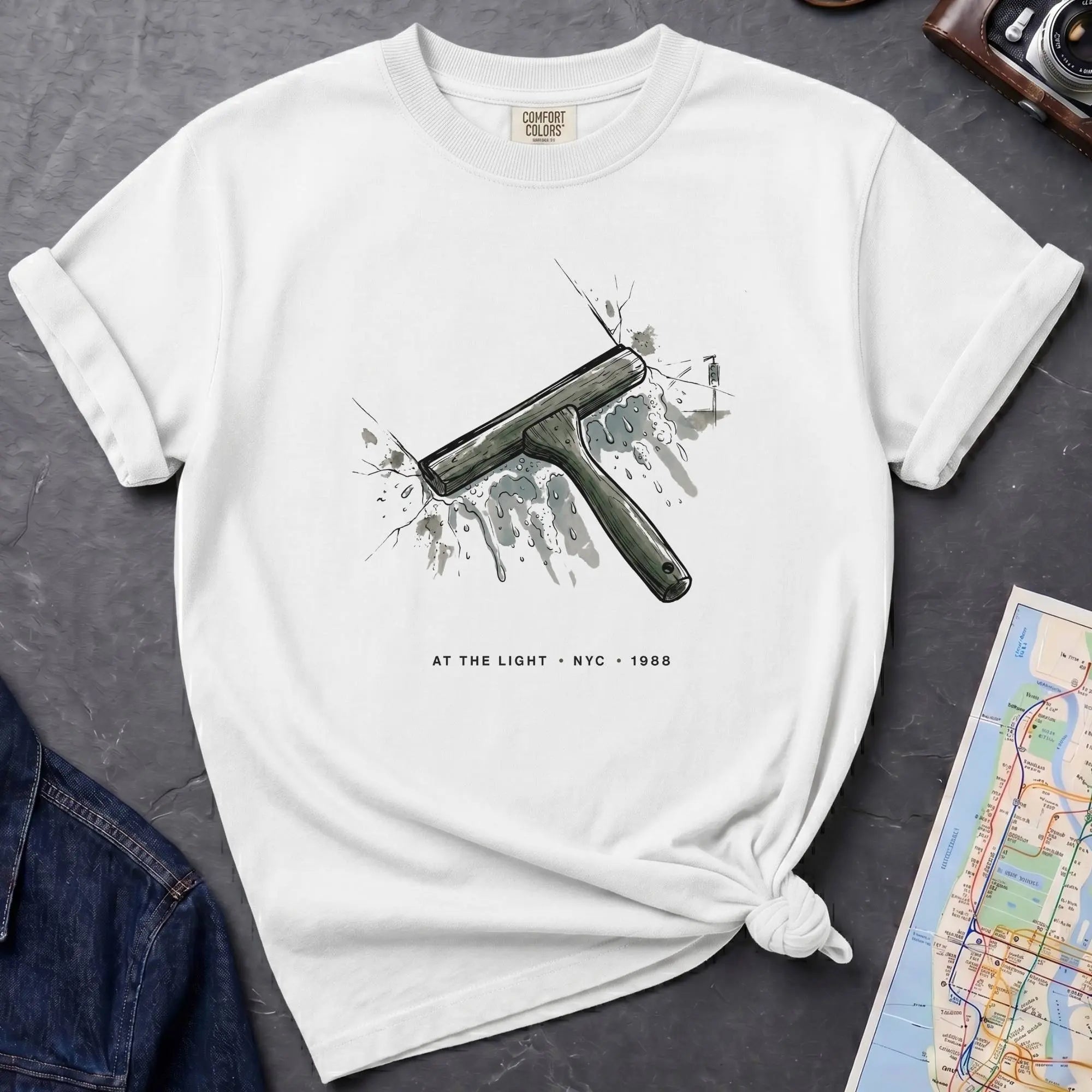White Comfort Colors t-shirt featuring a vintage windshield squeegee graphic with “At the Light • NYC • 1988” text.
