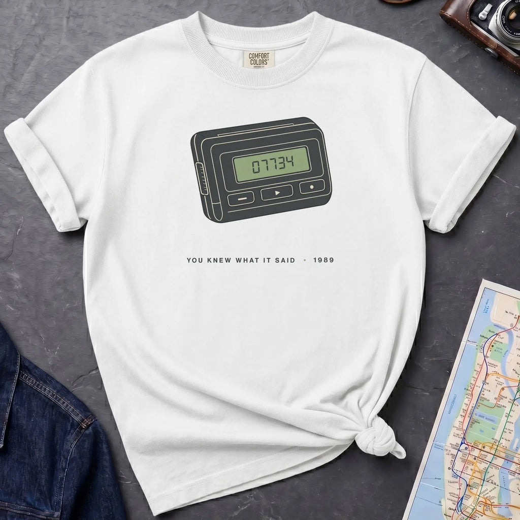 White Comfort Colors t-shirt featuring a retro pager graphic with “07734” on the screen and “You knew what it said • 1989” text.