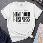 White Comfort Colors t-shirt featuring bold New York City “Mind Your Business, We’ll All Be Fine” text in a vintage black typography design.