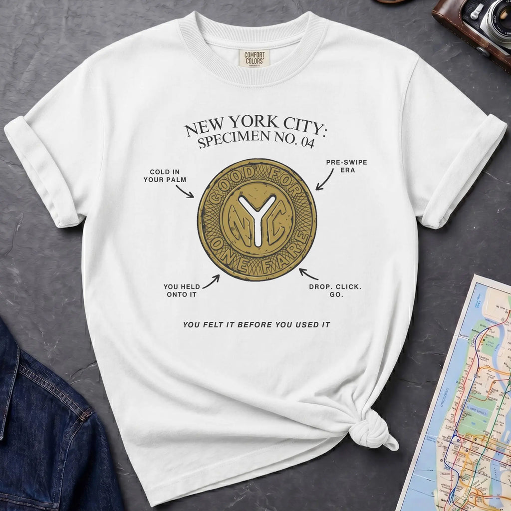 White Comfort Colors t-shirt featuring a vintage New York City subway token graphic with specimen-style callouts and “You felt it before you used it” text.
