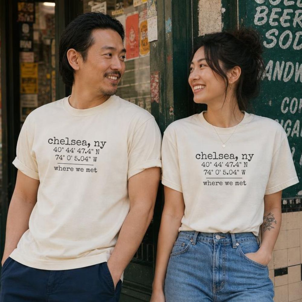 Two people wearing matching Comfort Colors t-shirts with coordinates and text 'where we met' in front of a store.